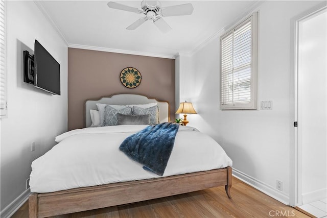 bedroom with baseboards, ornamental molding, ceiling fan, and wood finished floors