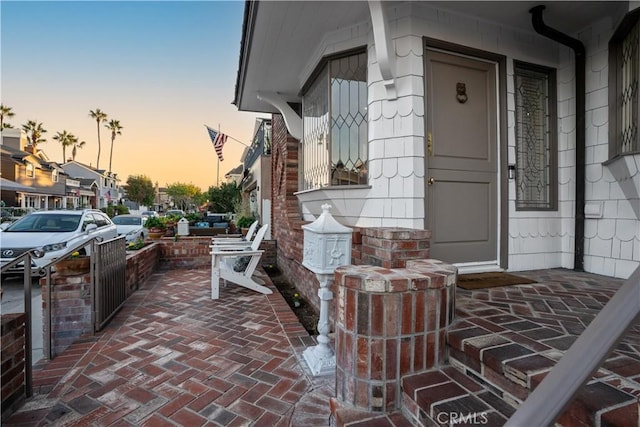 exterior entry at dusk featuring a porch
