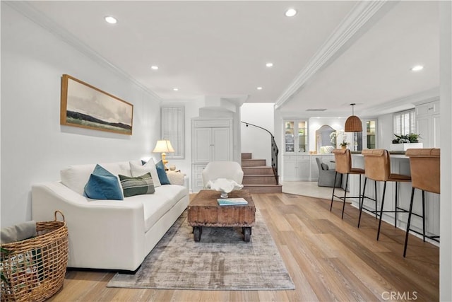 living area with recessed lighting, light wood-style flooring, stairs, and crown molding