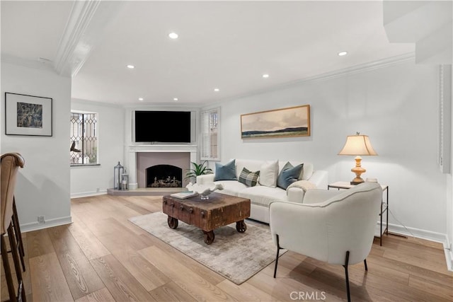 living room featuring crown molding, baseboards, recessed lighting, and wood finished floors