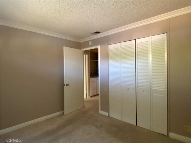 unfurnished bedroom with baseboards, a closet, crown molding, and a textured ceiling