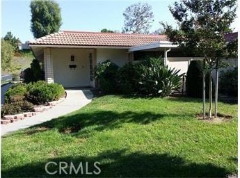 view of front of house featuring a tile roof and a front yard