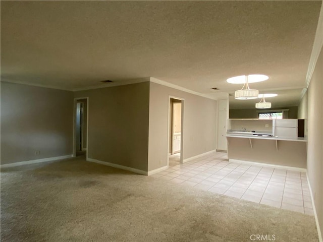 unfurnished living room featuring light tile patterned floors, ornamental molding, light colored carpet, and a textured ceiling