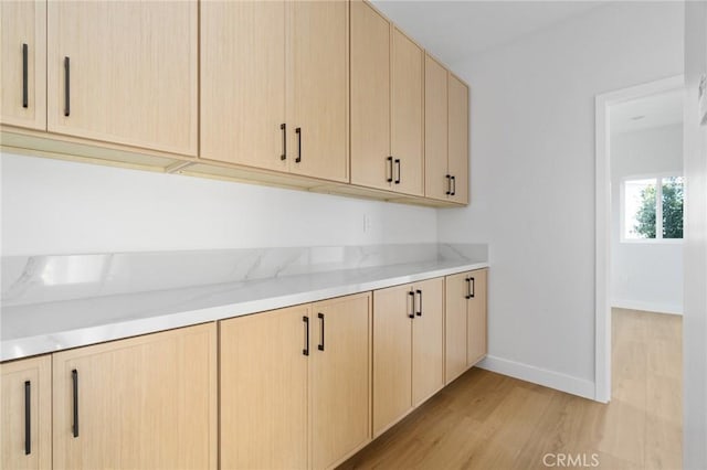 4641 W 130th St, Hawthorne, CA 90250 - kitchen with light brown cabinetry, light wood-style floors, baseboards, and light stone counters