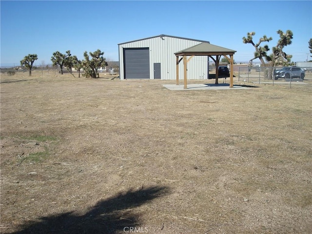 view of outdoor structure featuring an outbuilding, fence, and a gazebo