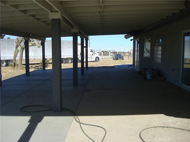 view of patio featuring an attached carport and fence