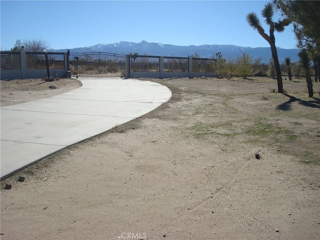 view of yard featuring a gate, a mountain view, and fence