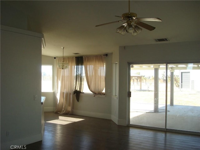 unfurnished room with a ceiling fan, wood finished floors, baseboards, and visible vents