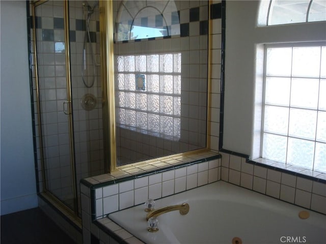 full bathroom with a bath and a shower stall
