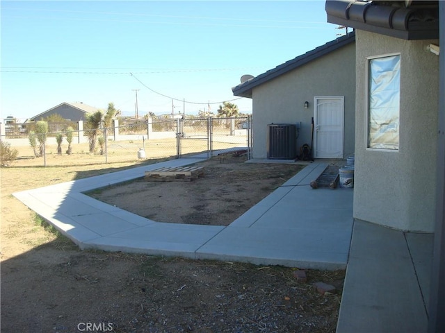 exterior space featuring a gate, fence, and central AC