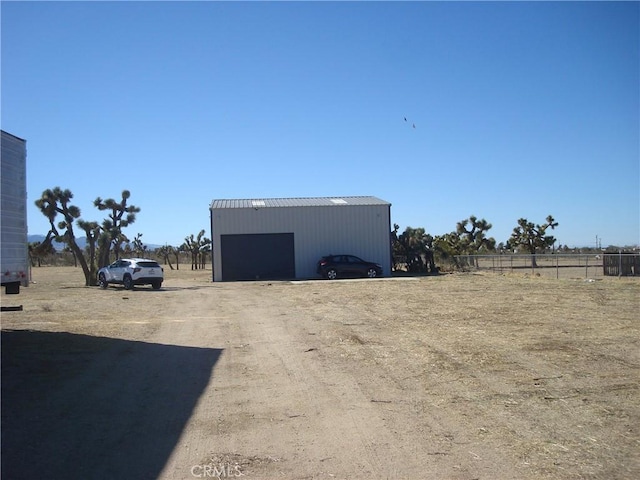 view of pole building with fence and a rural view