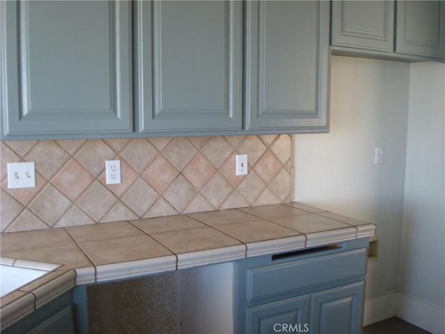 kitchen featuring decorative backsplash and tile countertops