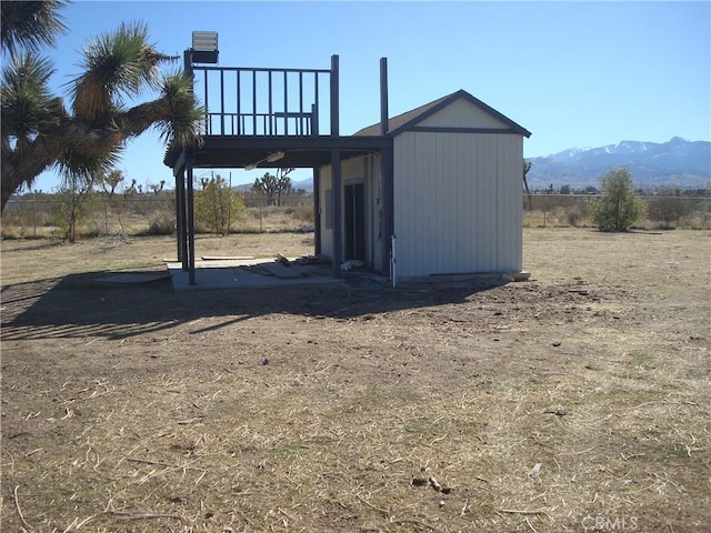 view of outbuilding with a mountain view and fence