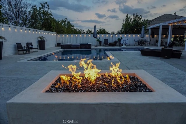 view of swimming pool with a patio, an outdoor fire pit, and fence