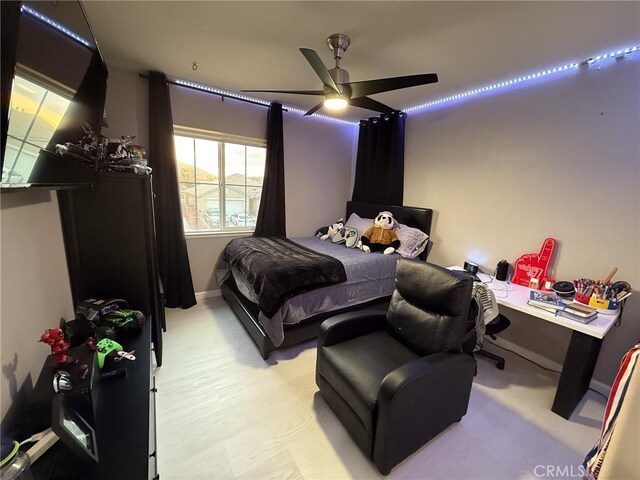bedroom featuring baseboards, light wood-style flooring, and a ceiling fan