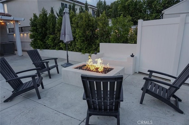 view of patio / terrace with central air condition unit, a fire pit, and fence