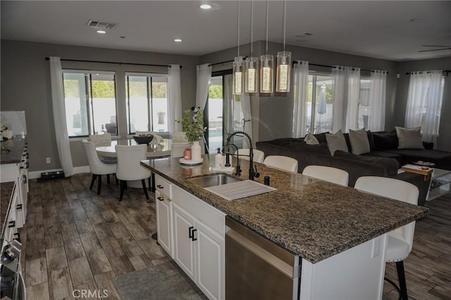 kitchen featuring open floor plan, a sink, dark wood-type flooring, and visible vents