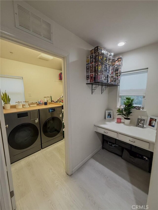 laundry room featuring washer and clothes dryer, baseboards, light wood-style floors, and laundry area