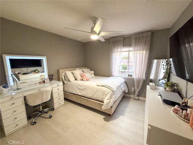 bedroom featuring baseboards, ceiling fan, and light wood finished floors