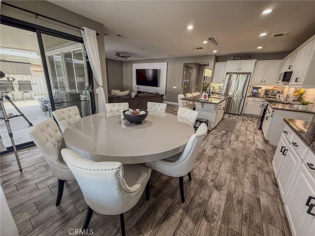 dining room with a healthy amount of sunlight, visible vents, and wood finish floors
