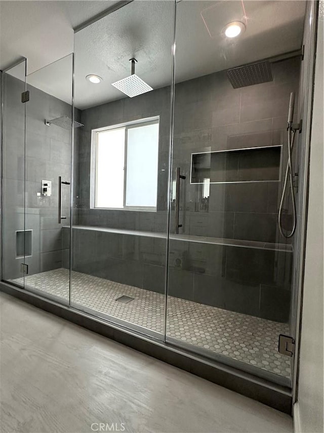 full bathroom with a shower stall and a textured ceiling
