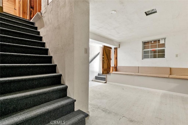 staircase with baseboards and concrete flooring