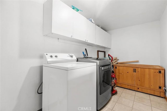 washroom with light tile patterned floors, cabinet space, and separate washer and dryer