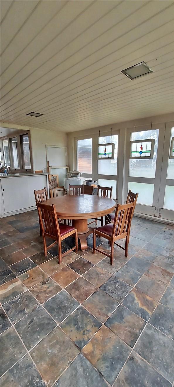 dining room with wooden ceiling, french doors, and stone tile flooring