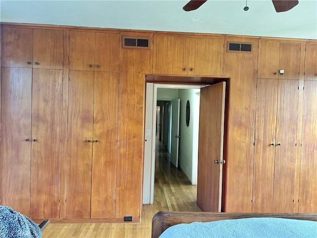 bedroom featuring light wood-style flooring, ceiling fan, and visible vents