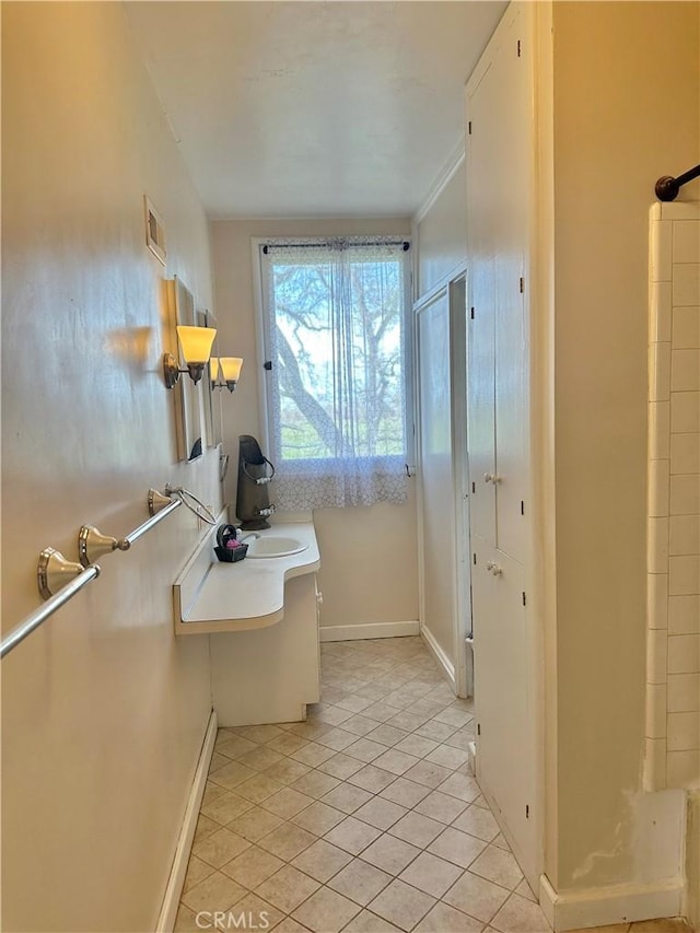 bathroom with tile patterned flooring, a sink, baseboards, and visible vents