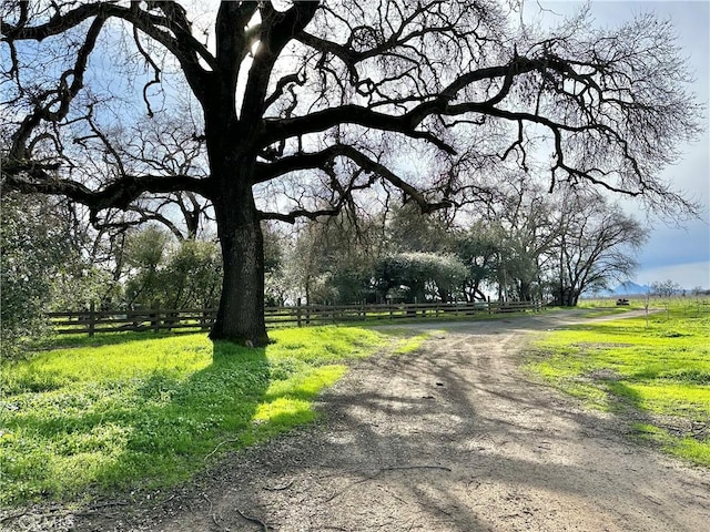 view of home's community with fence and a rural view