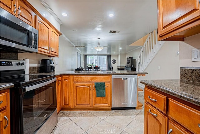 25301 Pine Creek Ln, Wilmington, CA 90744 - kitchen with stainless steel appliances, a sink, light tile patterned flooring, brown cabinetry, and ornamental molding