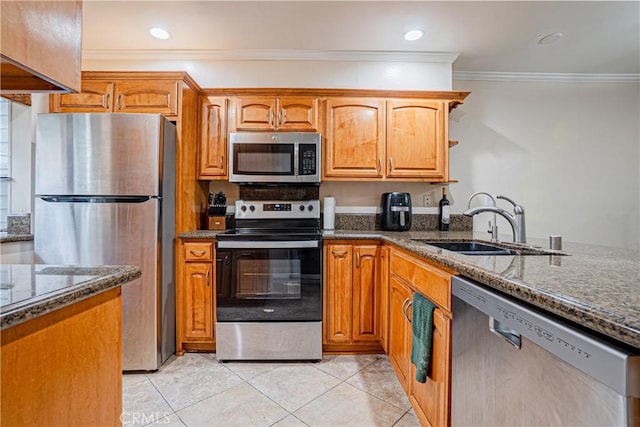 25301 Pine Creek Ln, Wilmington, CA 90744 - kitchen featuring appliances with stainless steel finishes, dark stone counters, crown molding, a sink, and light tile patterned flooring