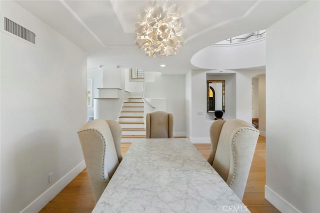 7 Suprema Dr, Newport Coast, CA 92657 - dining room with a chandelier, arched walkways, stairs, and light wood-style flooring