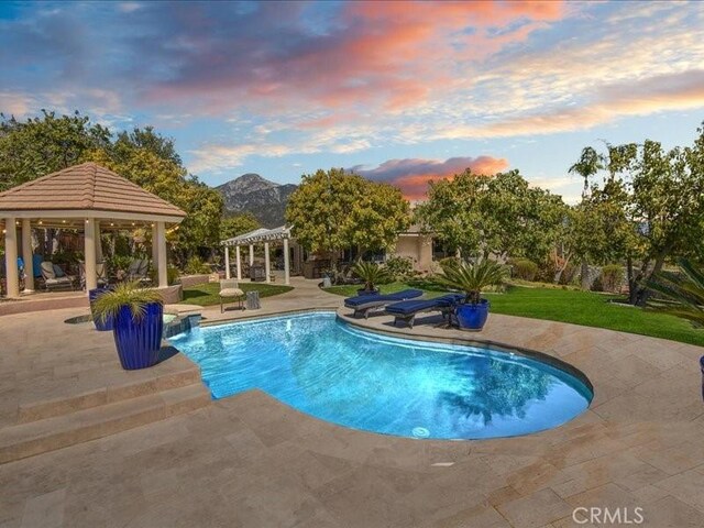 2565 Cliff Rd, Upland, CA 91784 - pool at dusk with a mountain view, a pergola, a gazebo, a patio area, and an outdoor pool