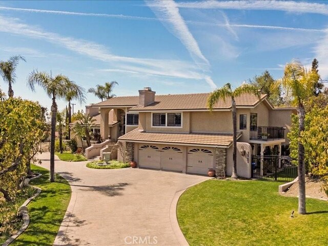2565 Cliff Rd, Upland, CA 91784 - view of front of home with an attached garage, concrete driveway, stucco siding, a front yard, and a chimney