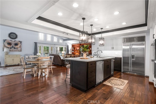2565 Cliff Rd, Upland, CA 91784 - kitchen with appliances with stainless steel finishes, light countertops, ornamental molding, backsplash, and a kitchen island with sink
