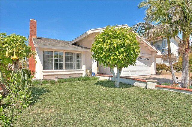 view of front facade featuring an attached garage, a front yard, a chimney, and stucco siding