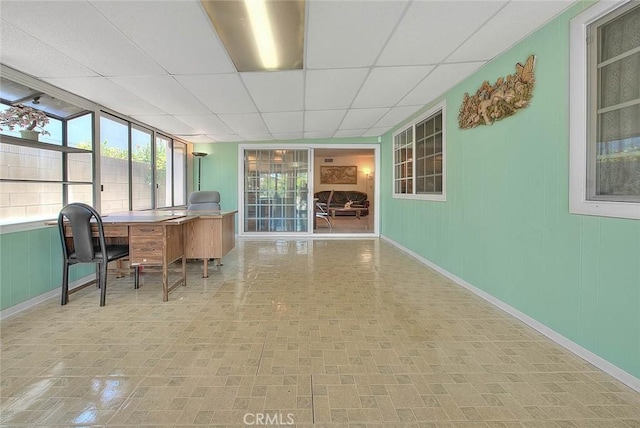 sunroom with a drop ceiling and baseboards