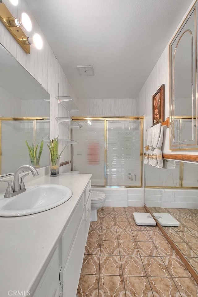 full bath featuring toilet, vanity, enclosed tub / shower combo, and tile patterned floors