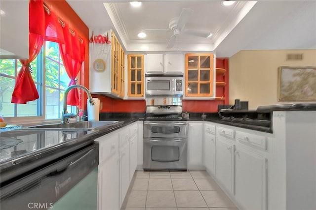 kitchen featuring stainless steel appliances, ornamental molding, a sink, dark countertops, and light tile patterned floors