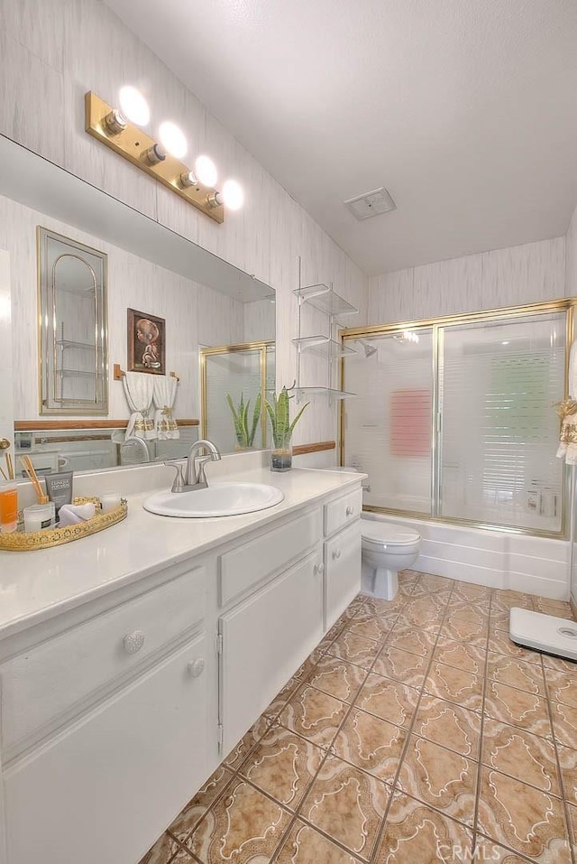 full bathroom with toilet, combined bath / shower with glass door, vanity, and tile patterned flooring