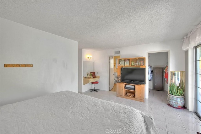 bedroom featuring a textured ceiling and light tile patterned flooring