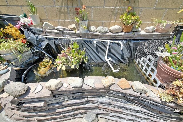 exterior view of a garden pond and concrete block siding