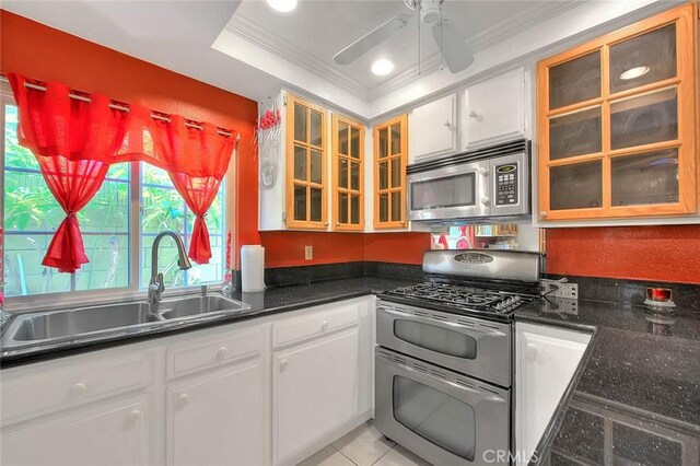 kitchen with appliances with stainless steel finishes, a sink, ornamental molding, a ceiling fan, and white cabinets