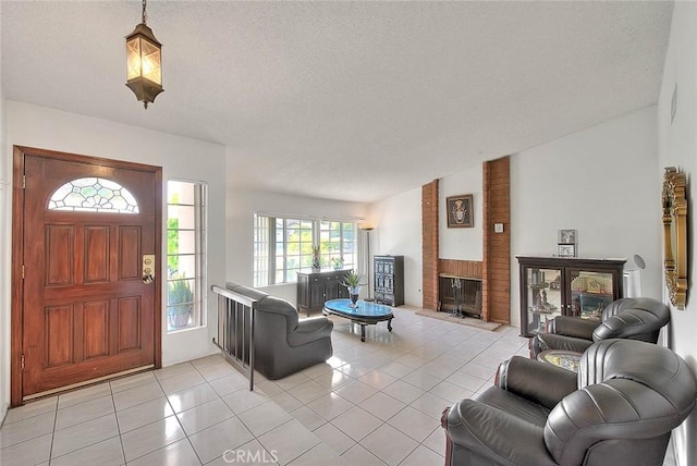 entryway featuring a brick fireplace, light tile patterned floors, and a textured ceiling