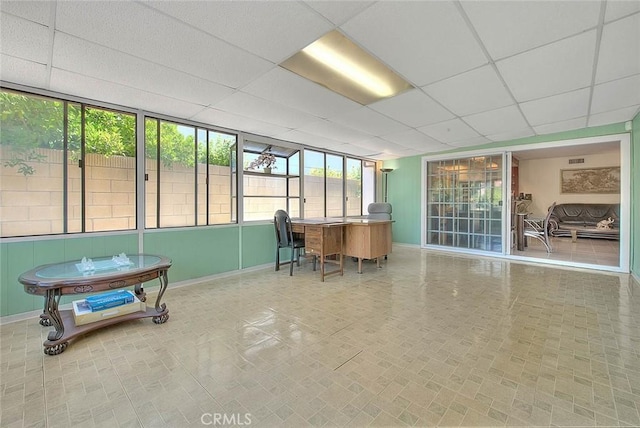 office space featuring baseboards and a paneled ceiling