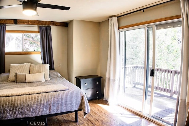 bedroom with access to exterior and wood finished floors