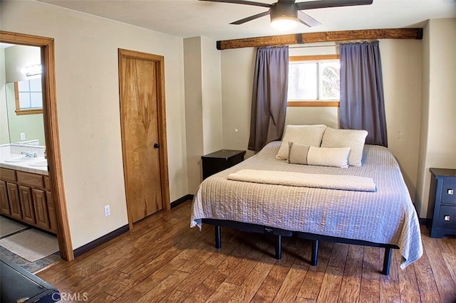 bedroom featuring connected bathroom, a sink, hardwood / wood-style flooring, a ceiling fan, and baseboards