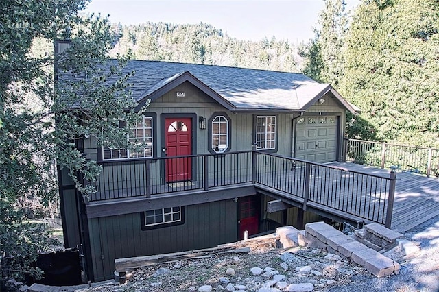 view of front of house with driveway, a garage, and roof with shingles